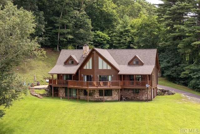 rear view of house featuring a yard and a deck