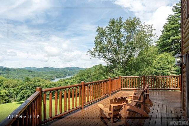 wooden terrace featuring a water and mountain view