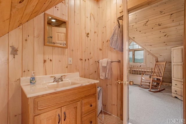 bathroom featuring lofted ceiling, wooden walls, and vanity