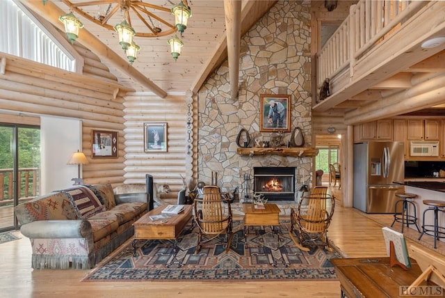 living room with a fireplace, high vaulted ceiling, light hardwood / wood-style floors, and rustic walls