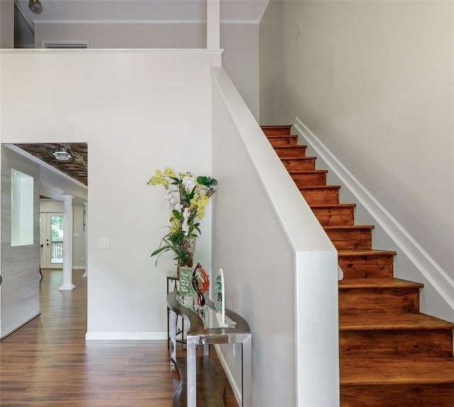 staircase with wood finished floors, decorative columns, baseboards, and visible vents