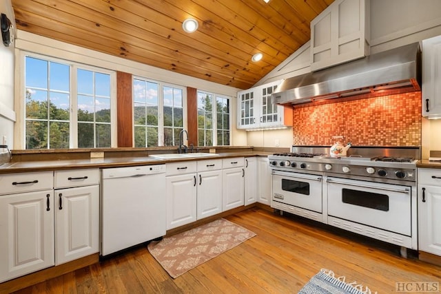 kitchen featuring white cabinetry, sink, white appliances, and wall chimney exhaust hood