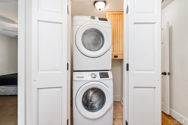 laundry room featuring cabinets and stacked washer / drying machine