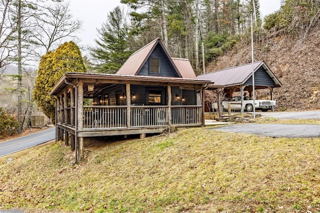 view of front of house with a porch, a front lawn, and metal roof