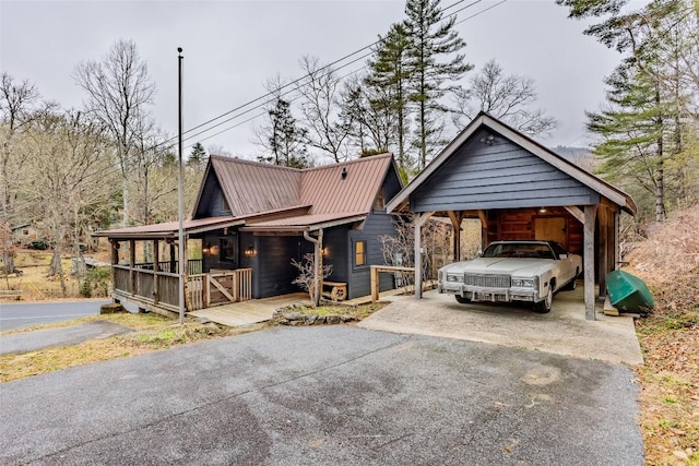 view of front of property with metal roof, driveway, and a carport