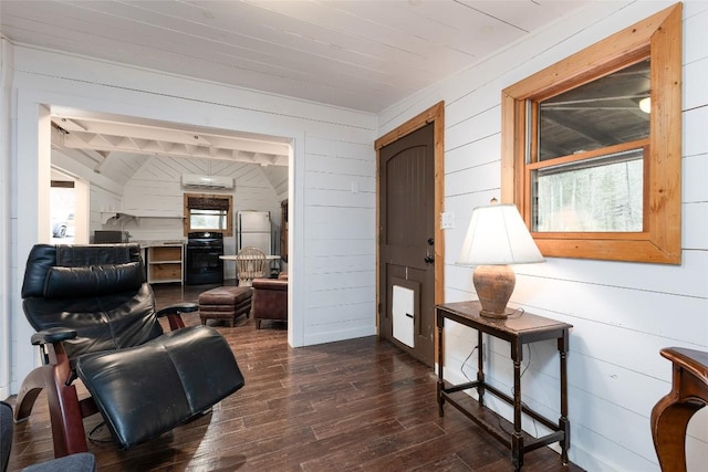 living room featuring dark wood-style floors, wood walls, and a wall mounted air conditioner