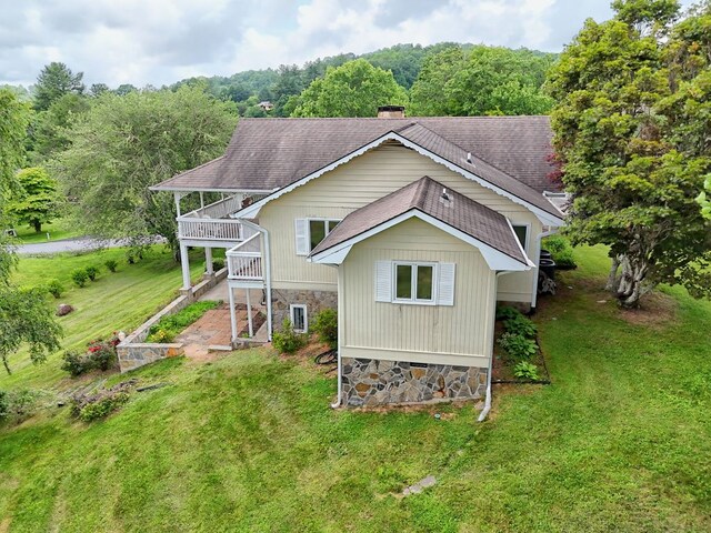 70 Fairway Ln, Sky Valley, GA 30537 - rear view of house featuring a yard, roof with shingles, a wooded view, and stone siding