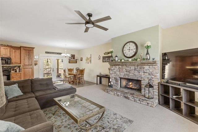 210 Triple Fork Rd, Cullowhee, NC 28723 - carpeted living room with ceiling fan, a fireplace, a chandelier, and french doors