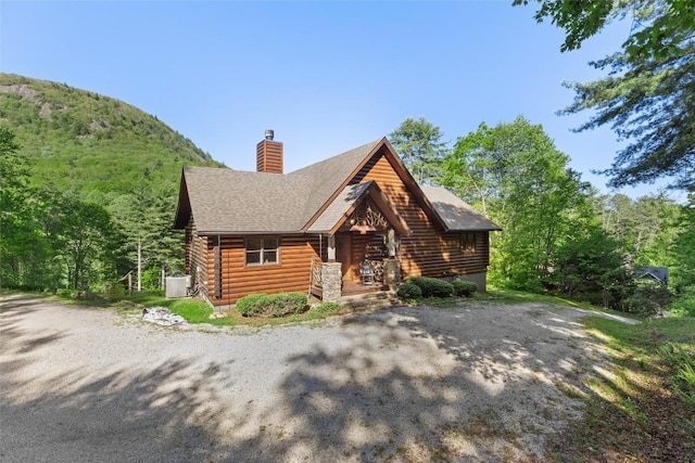 1318 Shortoff Rd, Highlands, NC 28741 - cabin with covered porch, a chimney, log siding, cooling unit, and a shingled roof