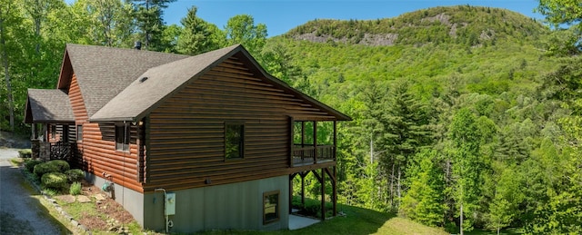 1318 Shortoff Rd, Highlands, NC 28741 - view of side of property with a wooded view, a shingled roof, and a deck with mountain view
