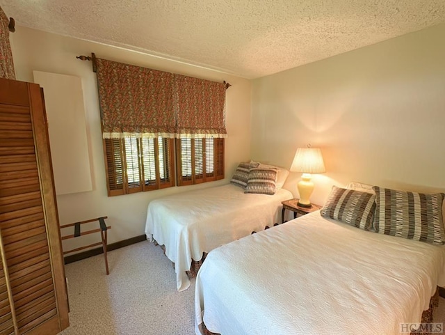 carpeted bedroom featuring a textured ceiling