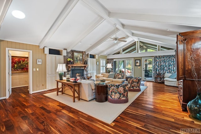 living room with ceiling fan, dark hardwood / wood-style floors, lofted ceiling with beams, and a stone fireplace