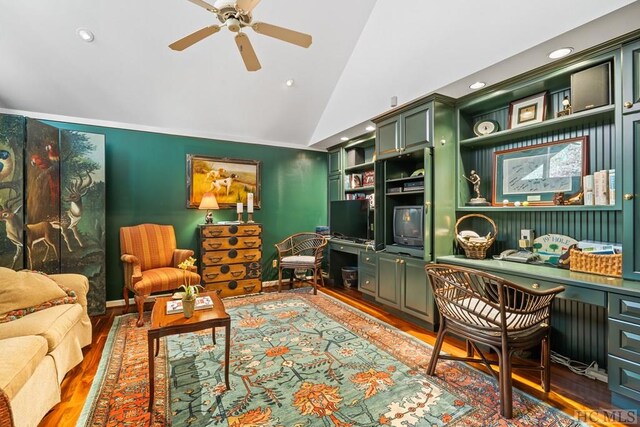 interior space with hardwood / wood-style flooring, built in features, ceiling fan, built in desk, and vaulted ceiling