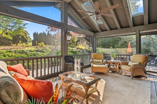 sunroom / solarium featuring ceiling fan, lofted ceiling with skylight, and plenty of natural light