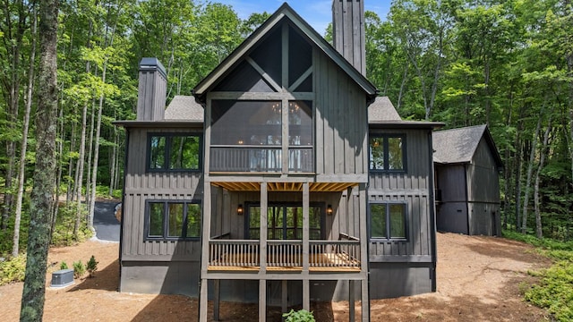 1310 New Settlers Way, Glenville, NC 28736 - back of house with a chimney, a shingled roof, a deck, board and batten siding, and a sunroom