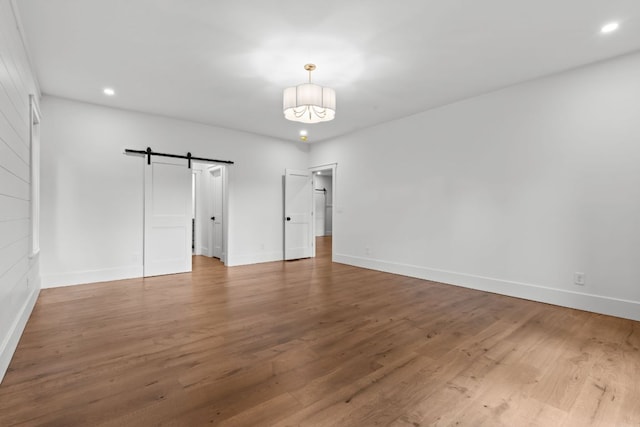 1310 New Settlers Way, Glenville, NC 28736 - unfurnished bedroom with a barn door, wood finished floors, and recessed lighting