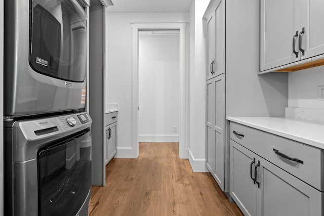 1310 New Settlers Way, Glenville, NC 28736 - washroom featuring cabinet space, stacked washer and clothes dryer, and light wood-style flooring