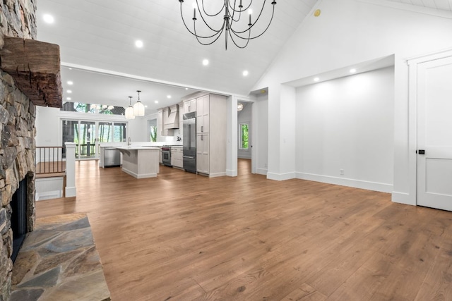 1310 New Settlers Way, Glenville, NC 28736 - unfurnished living room featuring a chandelier, high vaulted ceiling, plenty of natural light, wood finished floors, and recessed lighting