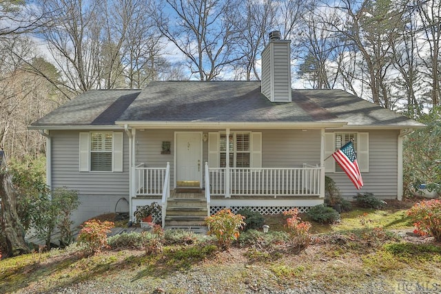 view of front of property featuring a chimney, covered porch, and roof with shingles