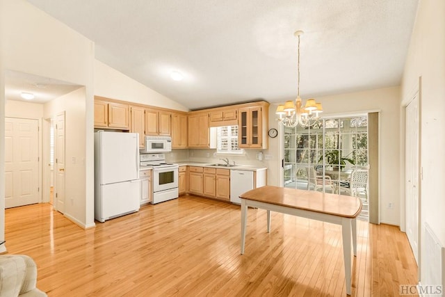 kitchen featuring decorative light fixtures, lofted ceiling, a notable chandelier, white appliances, and light hardwood / wood-style flooring