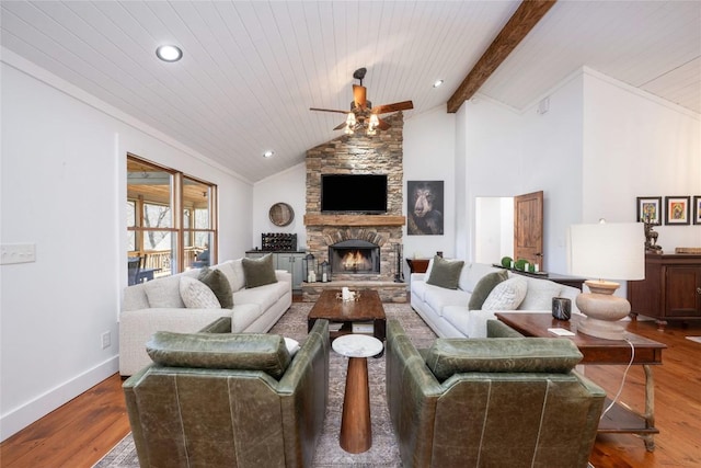 living room with a stone fireplace, wood finished floors, beam ceiling, and baseboards