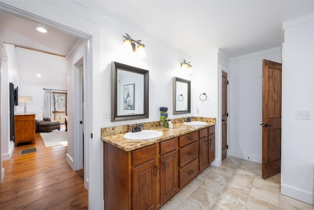 bathroom with visible vents, a sink, baseboards, and double vanity