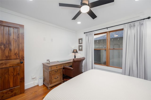 bedroom with crown molding, ceiling fan, light wood-type flooring, and baseboards