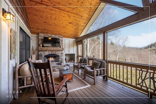 sunroom with wood ceiling, vaulted ceiling, and a fireplace