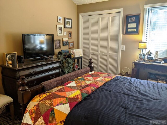 bedroom with a textured ceiling and a closet