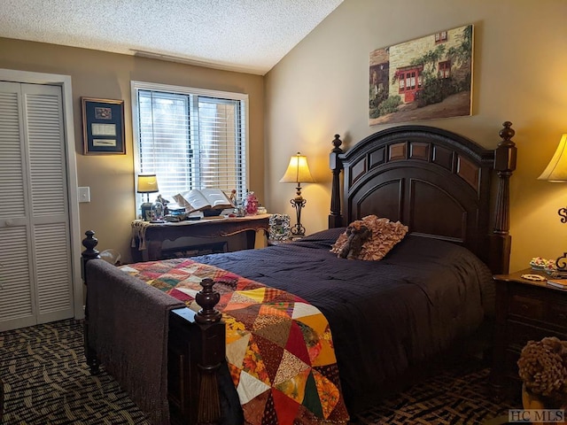 carpeted bedroom featuring vaulted ceiling, a textured ceiling, and a closet