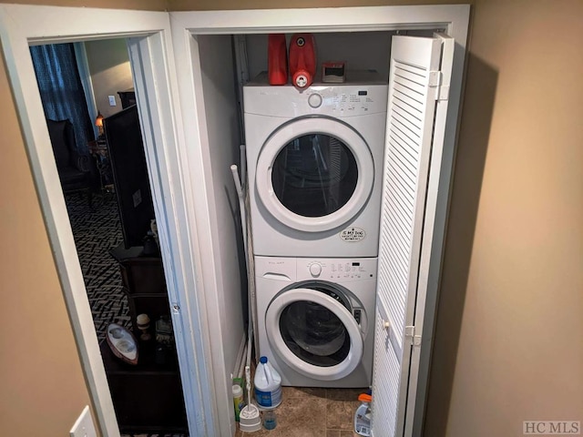 clothes washing area with stacked washer / dryer