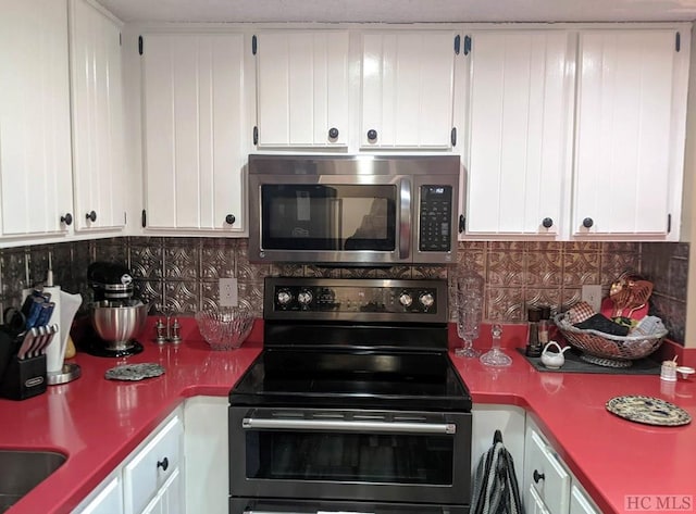 kitchen featuring backsplash, black range with electric cooktop, and white cabinets