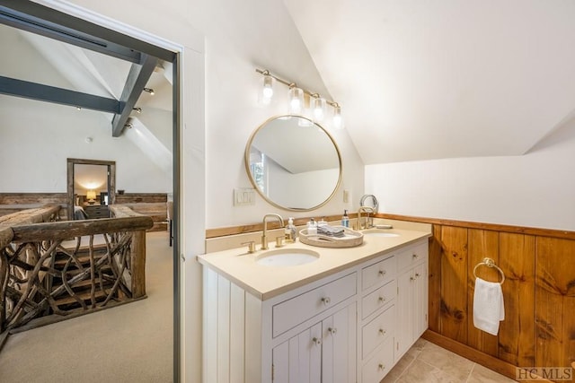 bathroom with tile patterned floors, lofted ceiling, and vanity