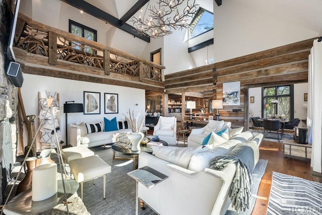 living room featuring high vaulted ceiling, wood walls, beamed ceiling, wood-type flooring, and an inviting chandelier