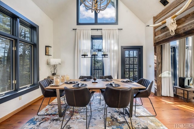 dining space with hardwood / wood-style flooring and high vaulted ceiling