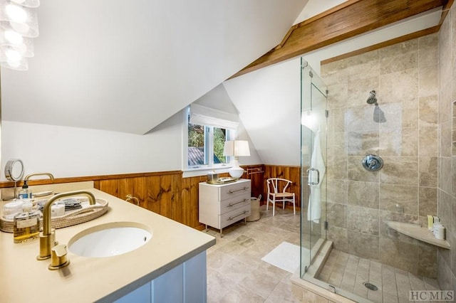 bathroom with lofted ceiling, an enclosed shower, vanity, and wood walls