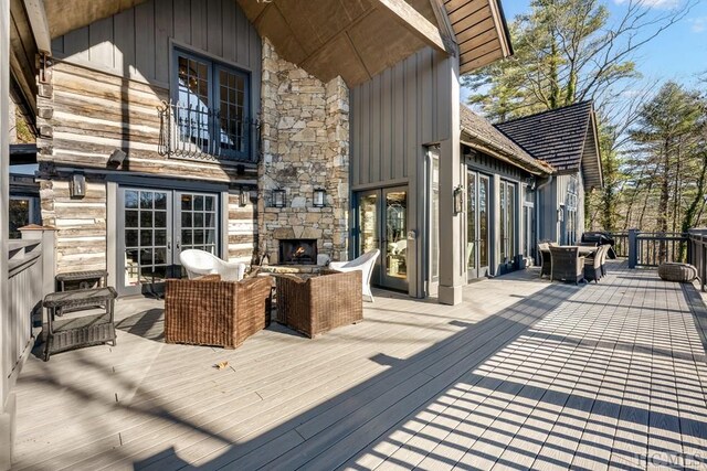 wooden deck featuring an outdoor stone fireplace