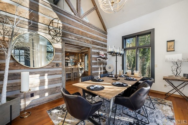 dining area featuring beam ceiling, hardwood / wood-style flooring, high vaulted ceiling, and a chandelier