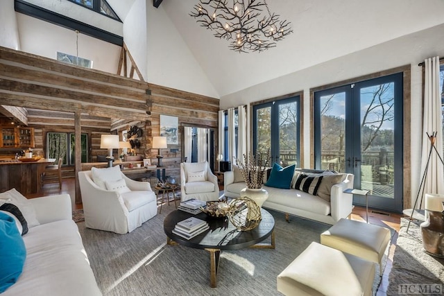 living room featuring hardwood / wood-style flooring, a towering ceiling, beam ceiling, and french doors