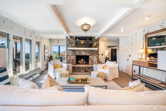 carpeted living room with beamed ceiling and a fireplace