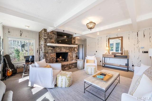 living room with a fireplace, beam ceiling, and light colored carpet