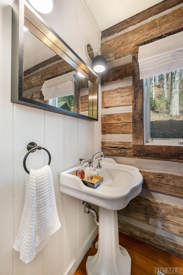 bathroom featuring hardwood / wood-style flooring and wooden walls