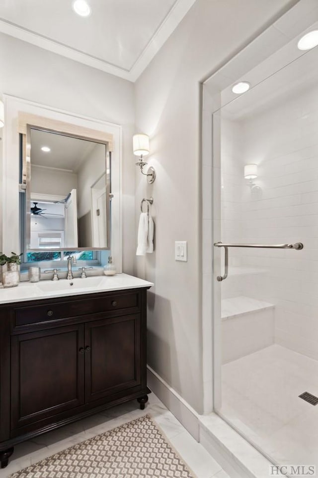 bathroom with vanity, crown molding, a shower with door, and ceiling fan