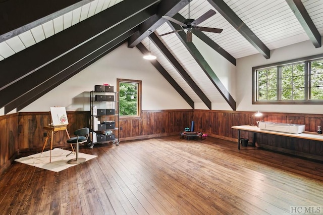 additional living space with wood-type flooring, lofted ceiling with beams, and wood walls