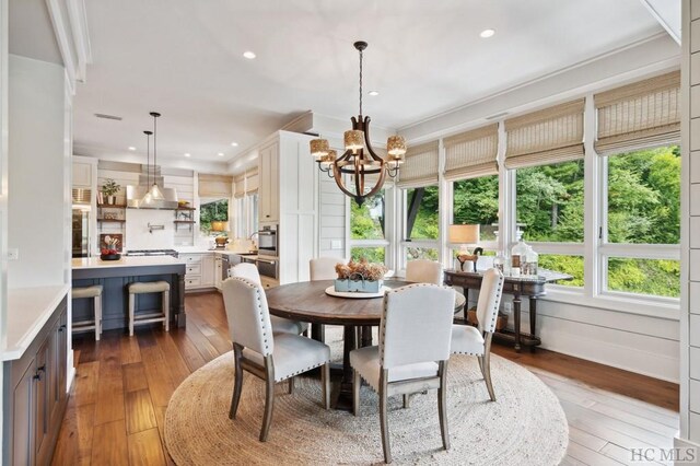 dining room with hardwood / wood-style flooring and an inviting chandelier