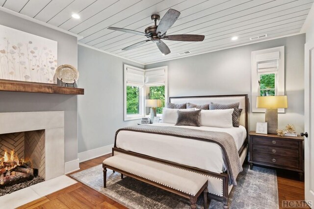 bedroom with wood ceiling, ceiling fan, wood-type flooring, and ornamental molding