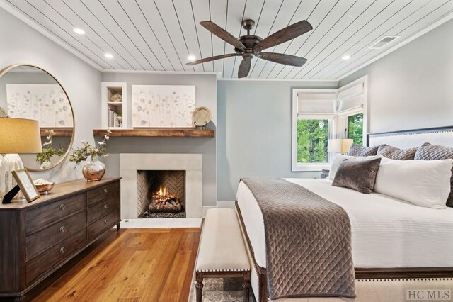 bedroom with wood ceiling, light hardwood / wood-style floors, and ceiling fan