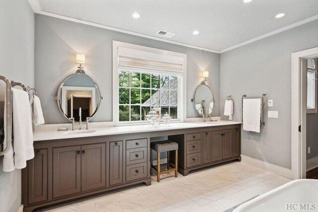 bathroom featuring crown molding, vanity, and a bathing tub