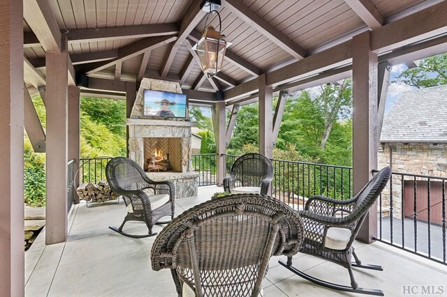 view of patio with a gazebo and an outdoor stone fireplace