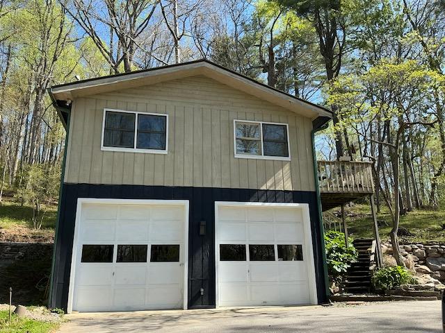 view of side of property featuring concrete driveway and a garage